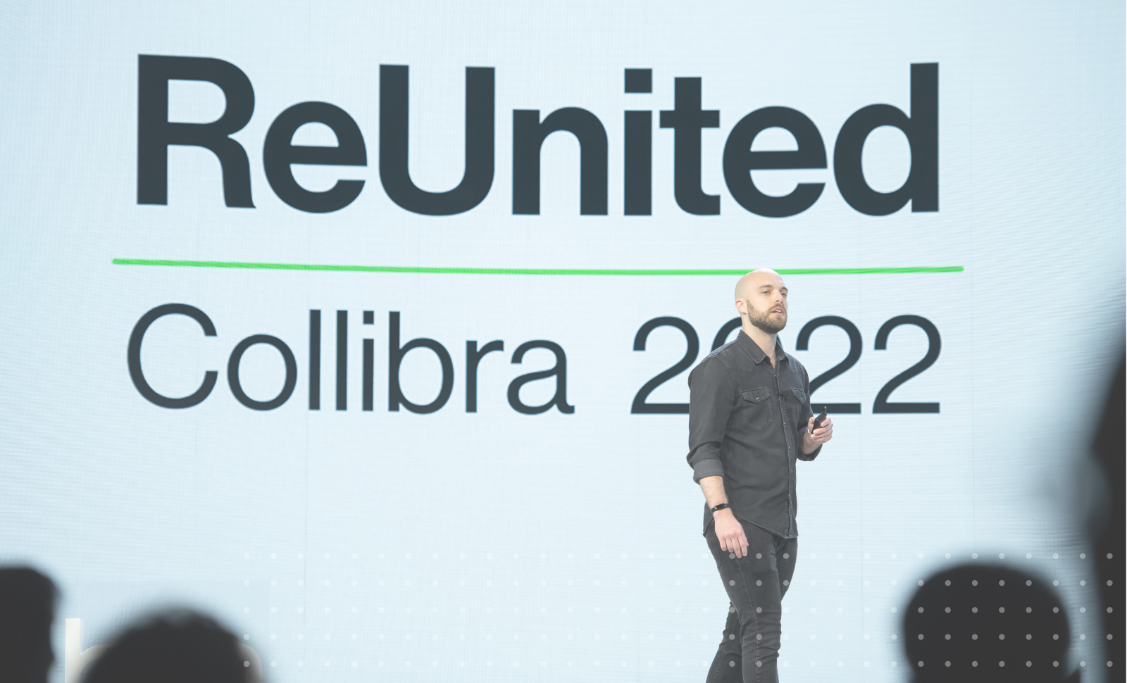 Cody Schrotel presents on stage in front a screen that reads ReUnited Collibra 2022