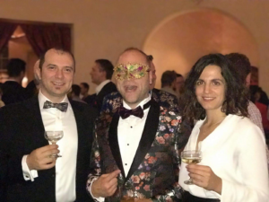 Tudor, Collibra founder, Stjin Christiaens, and Collibrian Laura Fontan smile for a photo at a staff party